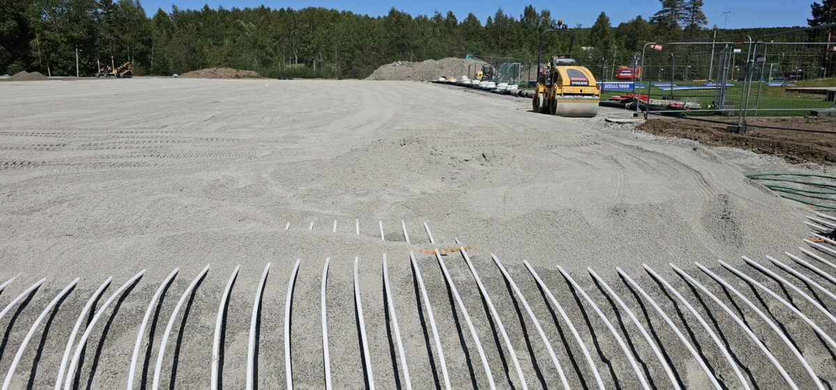 Konnerud – undervarme 2025 3 Delvis tildekket rørfelt og grusunderlag på Konnerud kunstgressbane.