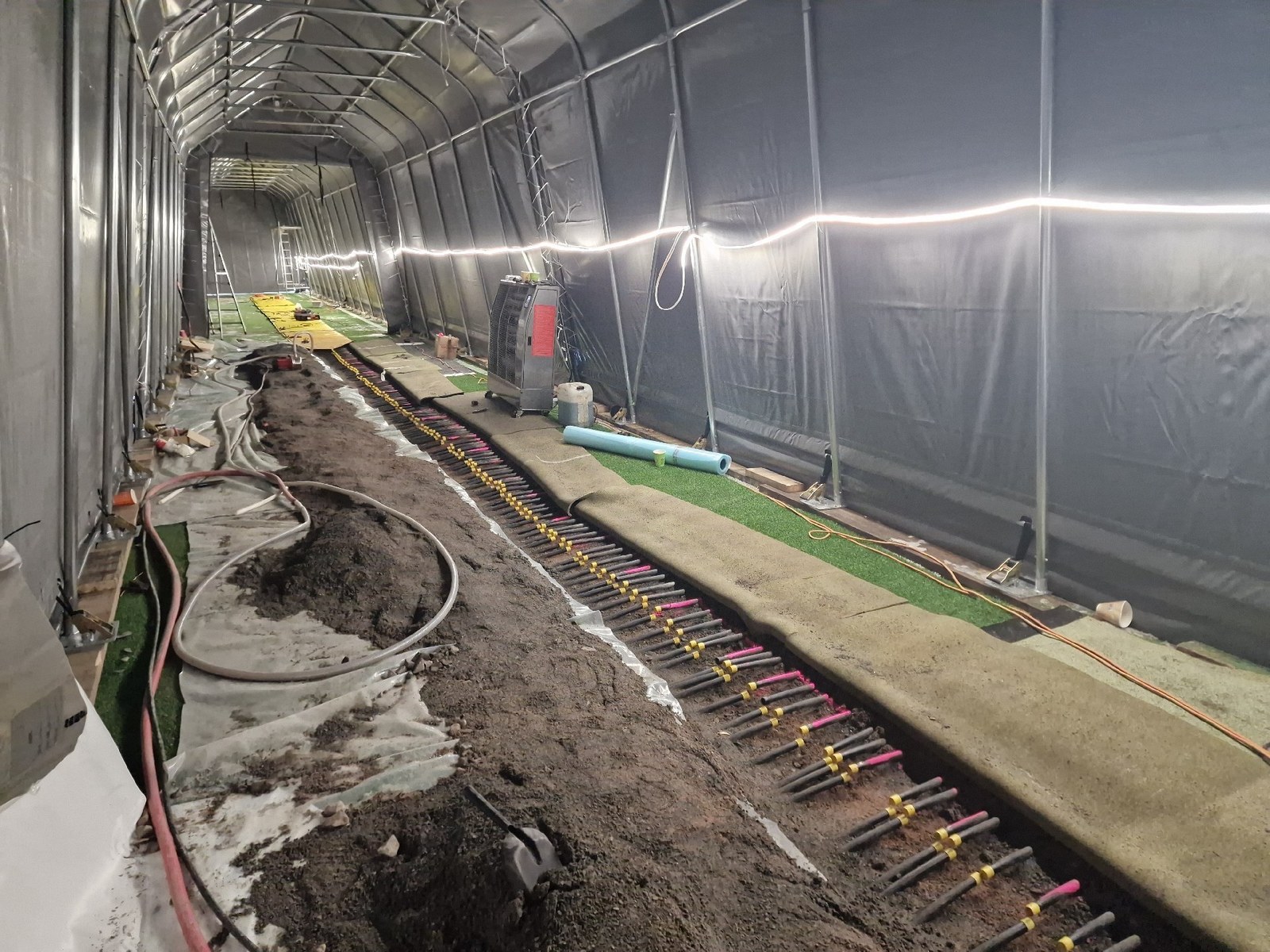 Banedekket åpnet langs samlestokken på Marienlyst i Drammen, undervarmerør frilagt for rensing, mars 2026
